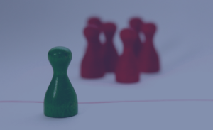 Eine einzelne Spielfigur ist durch eine rote Linie von einer Gruppe weiterer Spielfiguren getrennt